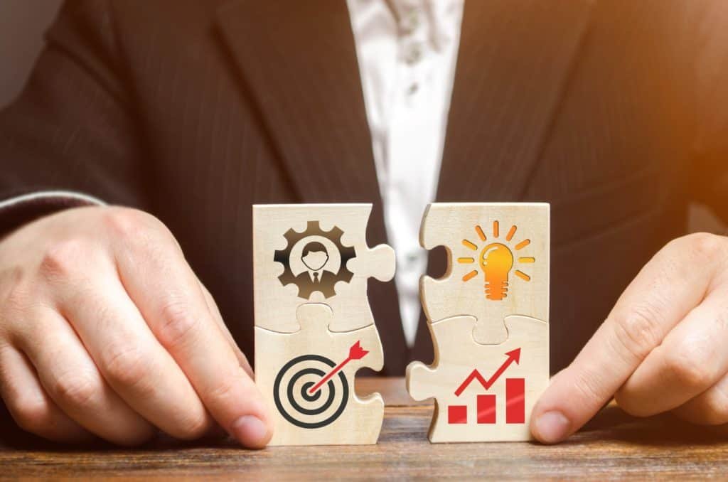 Businessman collects puzzles with the image of the attributes of doing business